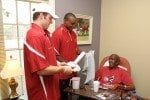 Alabama Crimson Tide players Greg McElroy and Luther Davis visit with Herman Hurst.